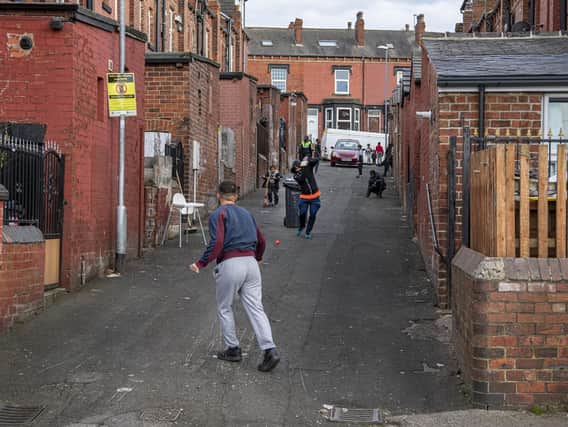 Young adults and children pictured playing street cricket in April 2021 in a back alley Hovingham Avenue, Harehills, Leeds. Picture Tony Johnson