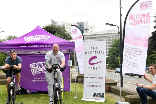 Nick Rank, manager of Forward Leeds' Kirkgate Hub (left) and John Fox, of the Hepatitis C Trust, on exercise bikes opposite Leeds Minster, to raise awareness on World Hepatitis Day. They are watched on by Peter Griffiths, a drug and alcohol worker.