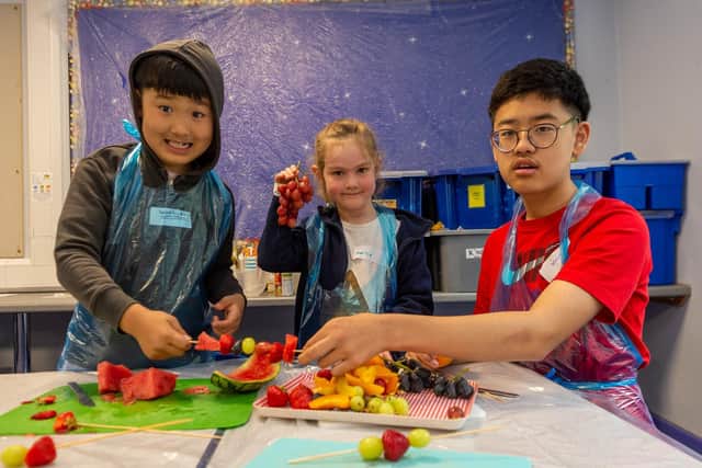 Children taking part in a cooking class making fruit kebab sticks (Left to right: Woohyeon Kwon, Maisie Arundel, and Woojin Kwon)