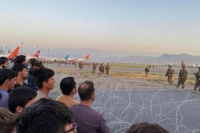 Afghans at Kabul airport are watched over by US troops.
Picture: Getty Images