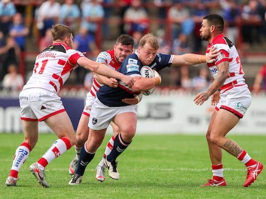 Liam Hood, second from left, tackles Trinity's Eddie Battye. Picture by Alex Whitehead/SWpix.com.