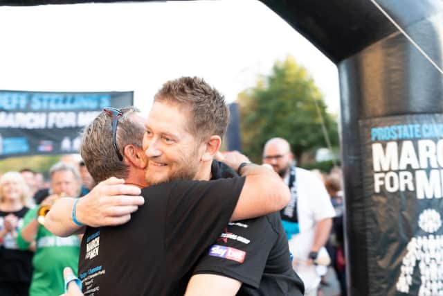 Lloyd embraces TV pundit Jeff Stelling during the March For Men 2019