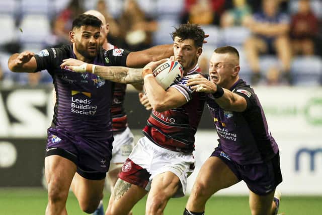 Wigan's Oliver Gildart is tackled by Leeds Rhinos' Harry Newman and Rhyse Martin. Picture: Paul Currie/SWpix.com.