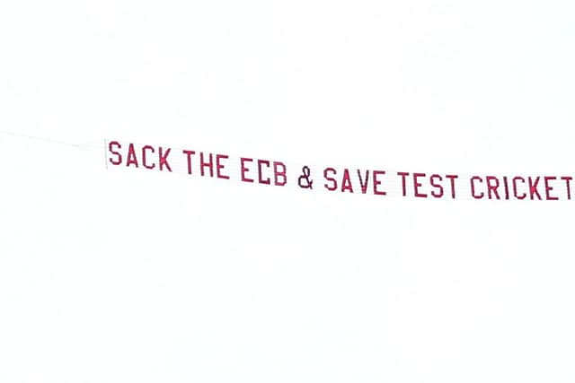 A plane with a banner reading 'Sack The ECB & Save Test Cricket' flies over ground.