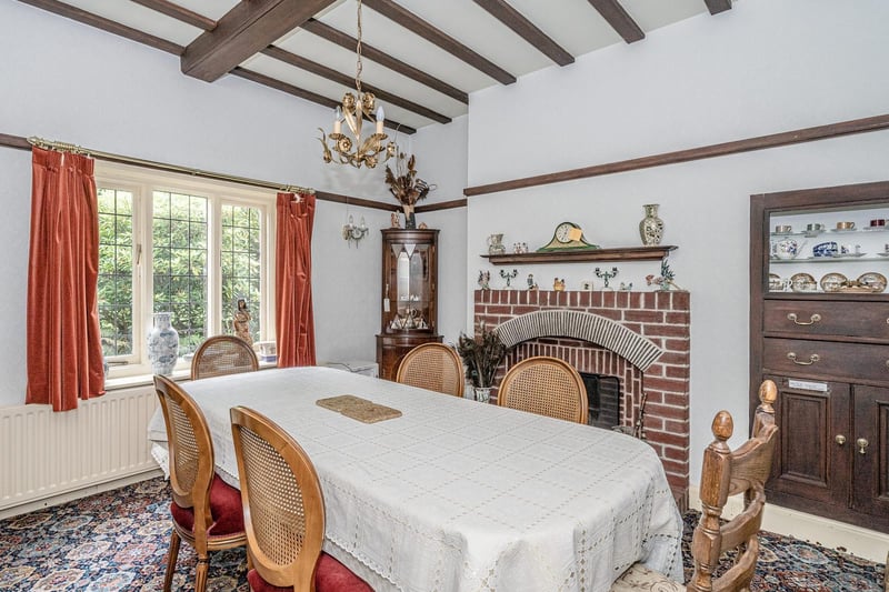 A fireplace and beamed ceiling are features of this dining room.