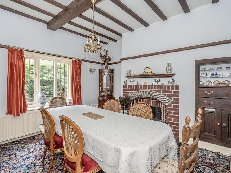A fireplace and beamed ceiling are features of this dining room.