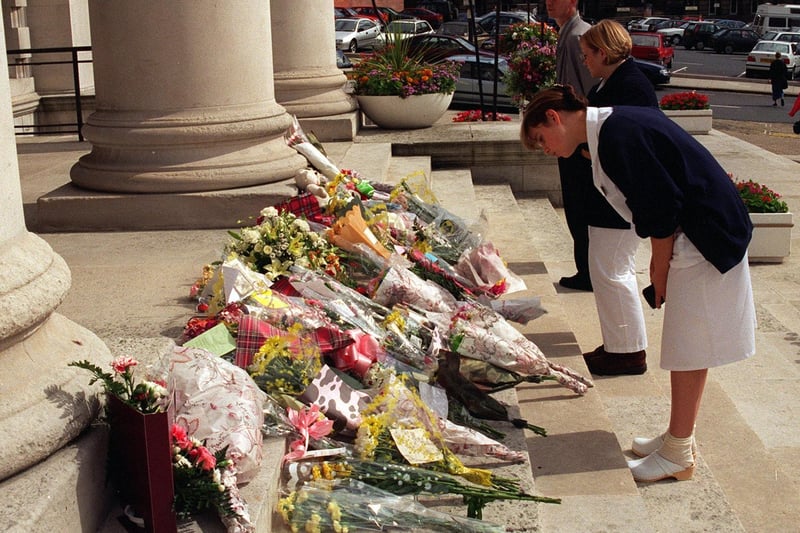 LGI workers look at floral tributes to Diana, Princess of Wales on the steps of Leeds Civic Hall.