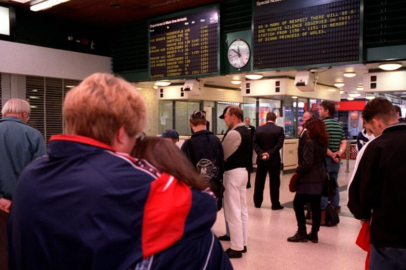 Rail passengers observe a minutes silence at Leeds City Station.