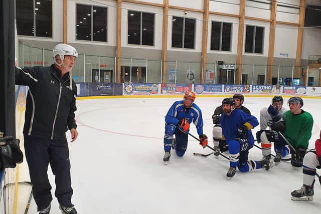 Sam Zajac, third right, listens to Leeds Knights head coach Dave Whistle run through a drill in practice.
