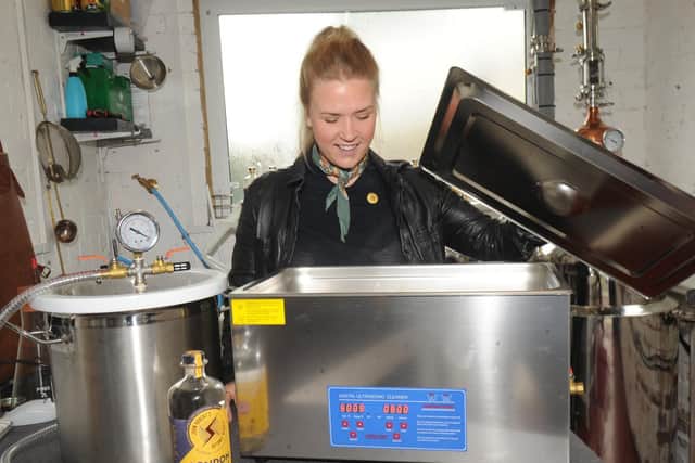 Emelie checks the ultrasonic bath, part of the innovative equipment used in the distilling process