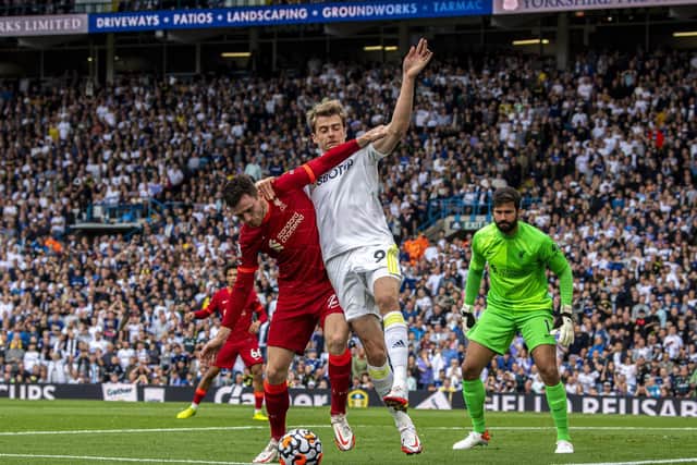 TOUGH DAY: For Leeds United and striker Patrick Bamford, centre, pictured tangling with Andy Robertson during Sunday's 3-0 defeat to Liverpool at Elland Road. Photo by Tony Johnson.