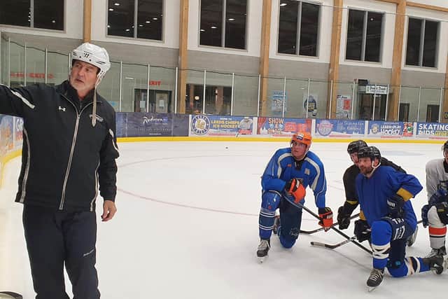 Sam Zajac, far right, listens as Leeds Knights head coach Dave Whistle gives out instructions during a practice session at Elland Road.