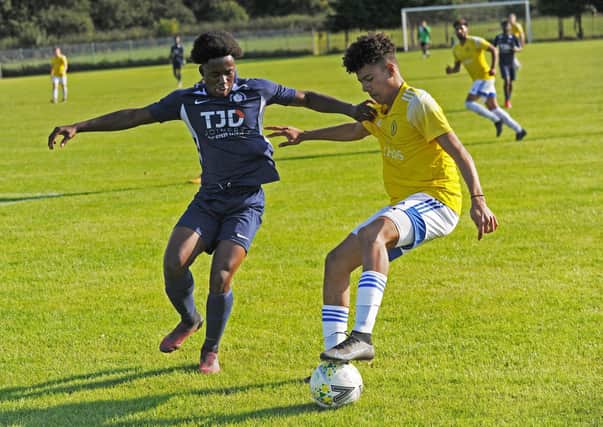 Theo Bailey, of Horsforth St Margarets, holds off Whitkirk Wanderers' Kenson Morton during Saturday's West Yorkshire League Premier encounter. Picture: Steve Riding.