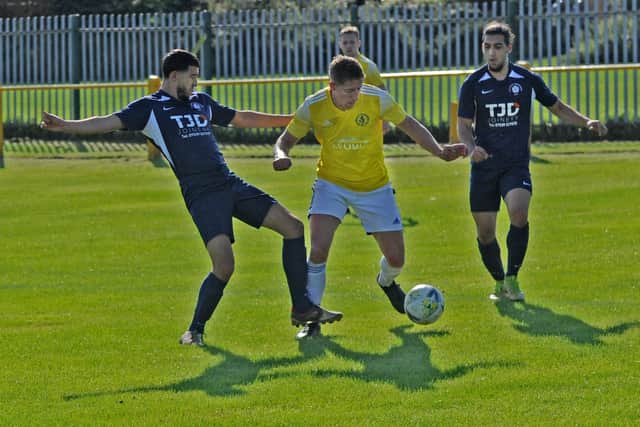 Luke Normam, of Horsforth St Margarets, squeezes between Whitkirk's Majed Alastta and Kadeem Morton. Picture: Steve Riding.
