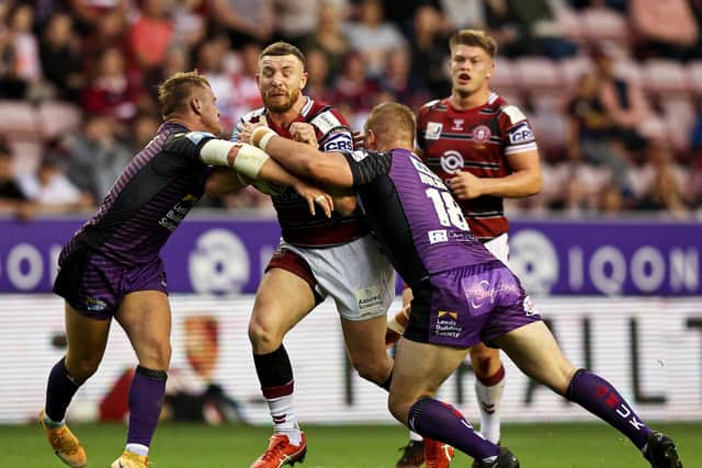Jackson Hastings of Wigan Warriors is tackled by Leeds Rhinos' duo Brad Dwyer and Tom Holroyd, the visitors winning 14-0. Picture by Paul Currie/SWpix.com