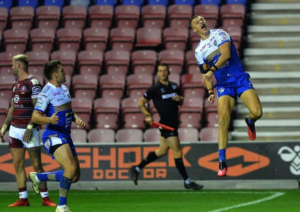 Victory leap: Rhinos' Ash Handley celebrates his crucial try against Wigan. Picture: Jonathan Gawthorpe