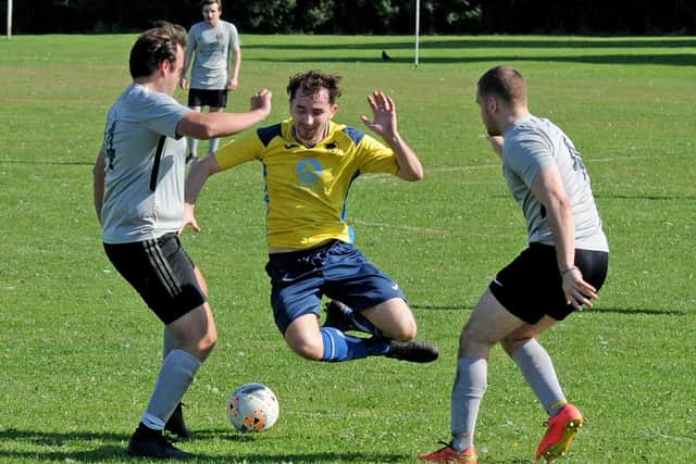 Brandon Smith of Leeds Alpha takes a tumble between Dan Angstmann and Jacob Mitchell of North Leodis. Picture: Steve Riding.