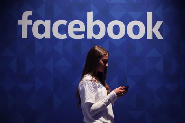 Library image of a woman using her phone under a logo of Facebook. Facebook has blamed a “faulty configuration change” for the widespread outage which impacted the social media platform, along with Instagram and WhatsApp, for several hours late on Monday.