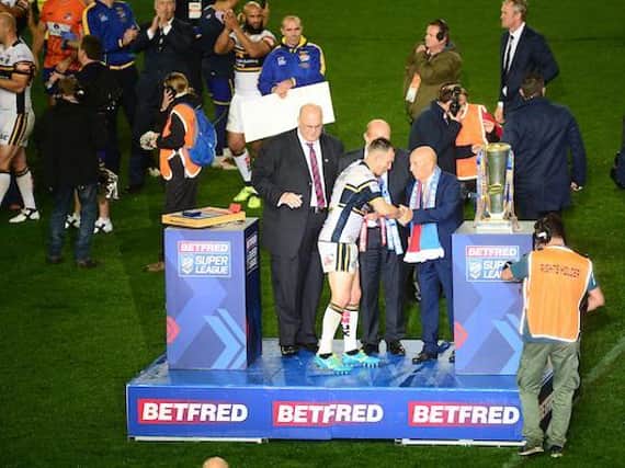 Fred Done presents the Super League trophy to Leeds Rhinos' Danny McGuire after the 2017 Grand Final. Picture by SWpix.com.