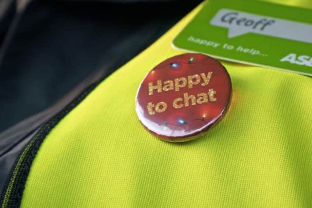 Library image of a 'Happy to Chat' badge worn by an Asda delivery driver