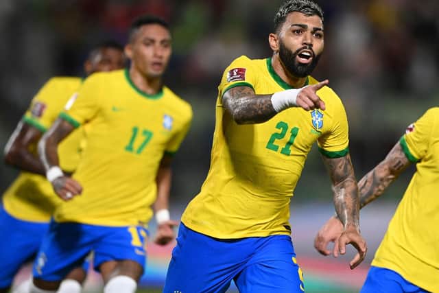 Brazil's Gabriel Barbosa celebrates after scoring against Venezuela with Raphinha following on. (Photo by YURI CORTEZ/AFP via Getty Images)