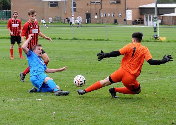 James Turner, of Alwoodley, scores past Lower Hopton goalkeeper Kieran Holmes during Saturday's Yorkshire Amateur League Supreme Division encounter. Picture: Steve Riding.