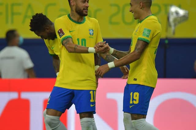 PARTNERING THE BEST: Leeds United winger Raphinha, right, celebrates with Neymar after starting the move that led to the Paris Saint-Germain star scoring the opener in Friday's 4-1 win against Uruguay. Photo by NELSON ALMEIDA/AFP via Getty Images.