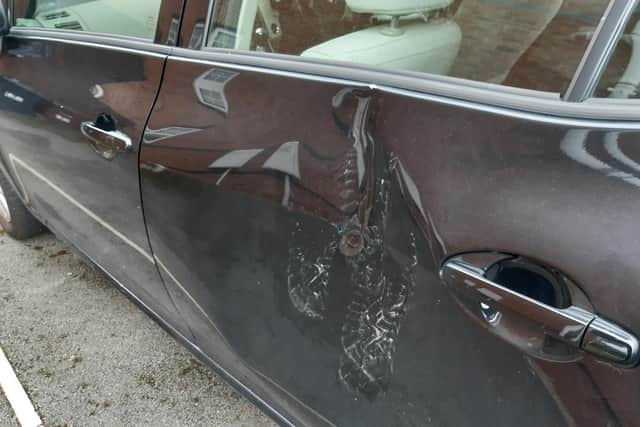 Footprints can clearly be seen on the woman's badly damaged car.