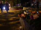 Two woman walking after dark past floral tributes to Sarah Everard in London (Photo: Yui Muk/PA Wire)