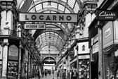 The County Arcade looking from the junction with Cross Arcade towards Briggate. On the left corner is Vickers gift shop selling silver, jewellery and watches. On the right, opposite, is a branch of Greenwoods menswear. Next right is the entrance to the Mecca Locarno Ballroom then Elster shoe shop.