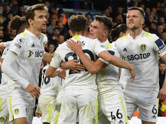 MAKING THEIR POINT: Diego Llorente, left, celebrates with his Leeds United team mates after Rodrigo's 94th-minute penalty seals a 1-1 draw against Wolves at Elland Road. Photo by OLI SCARFF/AFP via Getty Images.