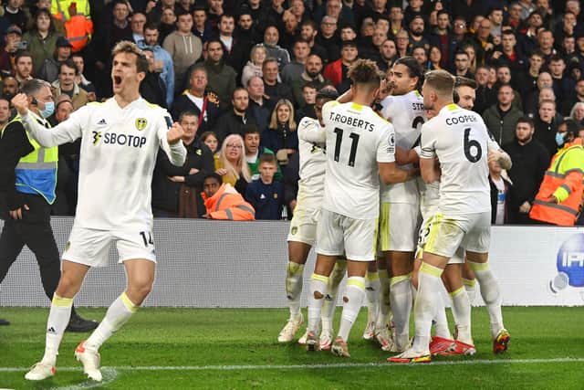 DEAFENING: Leeds United's Diego Llorente, left, gestures to the Elland Road faithful as Wolves' fans, behind, look on following Rodrigo's 94th-minute equaliser in Saturday's draw at Elland Road. Picture by Bruce Rollinson.
