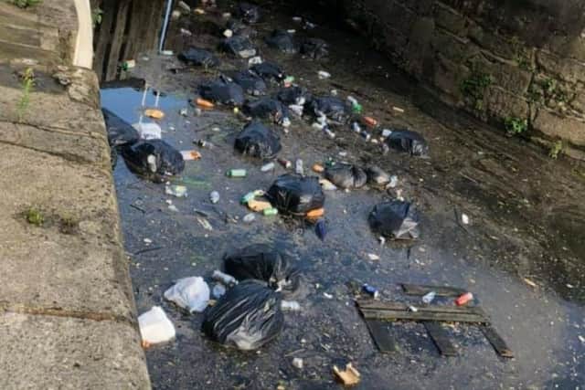 The couple took this photo of bags of rubbish dumped in the River Aire.