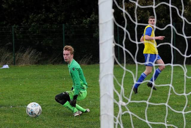 Cameron McNiven scores his second goal for Stanningley Old Boys past Leeds Modernians goalkeeper Matty Caines in his side's 7-0 win in Yorkshire Amateur League Division Three. Picture: Steve Riding.