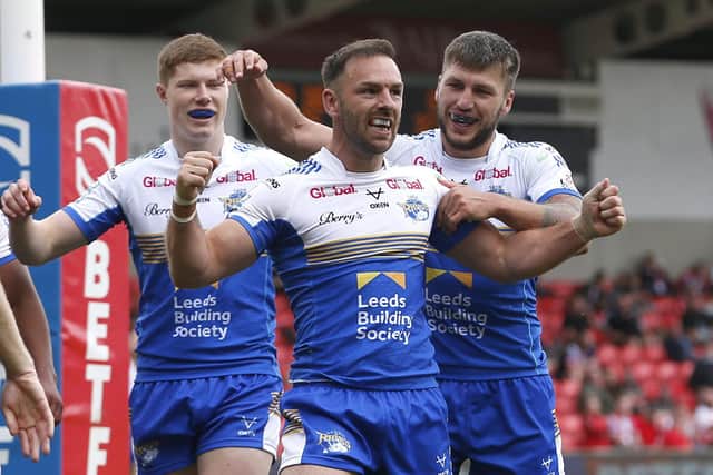 Luke Gale, centre, celebrates with Morgan Gannon, left and Tom Briscoe after scoring for Rhinos at Salford last year. Picture by Ed Sykes/SWpix.com.