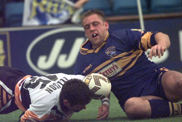 Andy Hay scores for Rhinos for Rhinos against Castleford in 1999, despite Danny Ellison's attempted tackle. Picture by Bruce Rollinson.