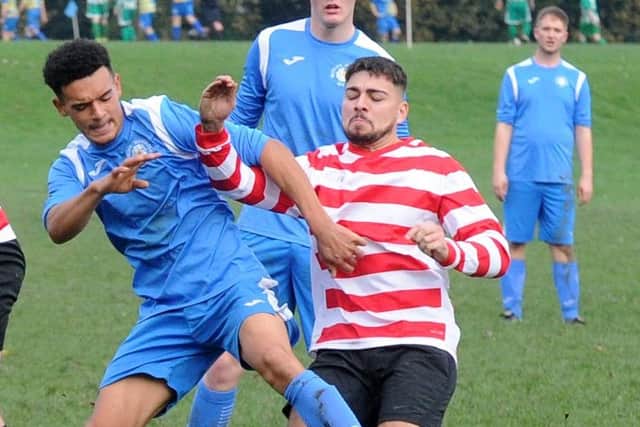 Josh Meredith of Whitkirk Wanderers Blues tangles with Leeds Hyde Park's Eddie Hussain. Picture: Steve Riding.