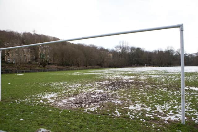 A snow and mud-covered football pitch