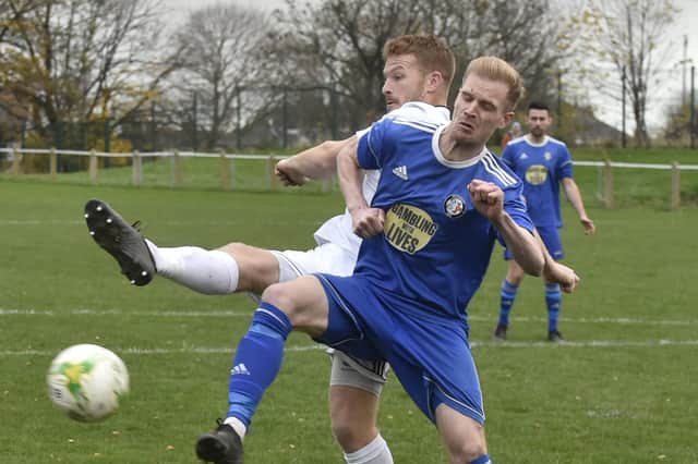 Tom Greaves, of Beeston St Anthonys, is thwarted by Headingley defender Richard Sadler during Saturday's Leeds and District Challenge Cup tie. Picture: Steve Riding.