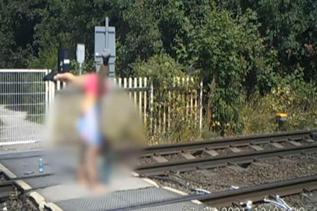 A teenage girl doing a handstand at a level crossing. The incident happened in Broxtowe, Nottinghamshire on a stretch of track used by trains travelling at up to 80mph. PIC: Network Rail/PA Wire
