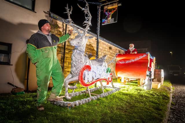 Jamie Tennant, 41, pictured with the life size Santa's sleigh outside his home (Photo: James Hardisty)