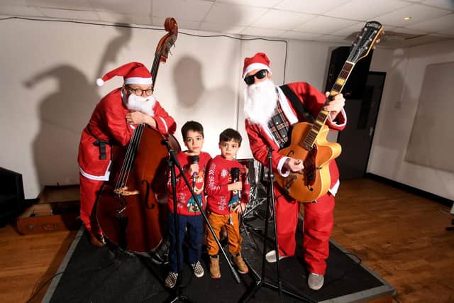 Brothers David Blackburn aged 8 (left) and his brother Sal record Christmas single for Charity at Eiger Studios, Leeds. with there dad Ian Blackburn (right) and Martyn Roper. Photo: Simon Hulme