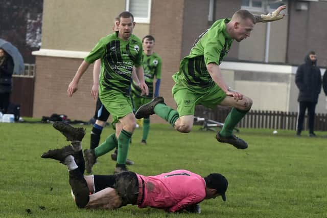 Neville Hill's Matty Bland hurdles Bird In Hand goalkeeper Graeme Ryan during Sunday's Leeds Combination League Division 5 encounter. Picture: Steve Riding.
