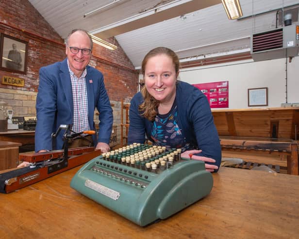 William Gaunt and Rachel Moaby with a comptometer, which was the first mechanical calculator used in the mill office, in the foreground and a crockmeter that tests the colour of the dye.