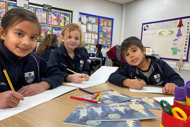 Some of the youngest pupils at Grammar School at Leeds writing Christmas messages to some of the eldest previous pupils at the school.