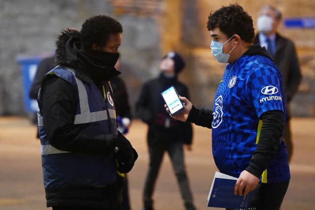 A Chelsea fan presents a COVID pass to gain entry to Stamford Bridge. Pic: Mike Hewitt.
