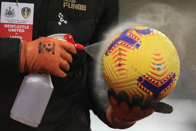 A Premier League ball is disinfected ahead of kick-off. Pic: Lindsey Parnaby.