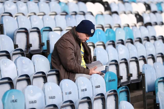 A Leeds United fan browses the matchday programme at Elland Road. Pic: George Wood.