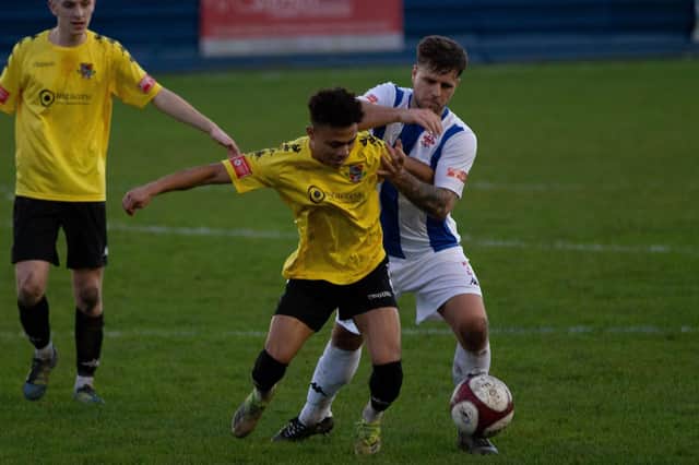 Pontefract Collieries' Joao Rangel and Liversedge FC's Adam Field battle for the ball in the New Year's Day derby at Clayborn.