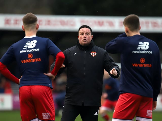Kettering Town manager Paul Cox gives his team instructions ahead of the game